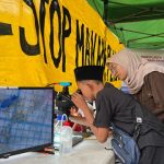 Ecoton mengajak masyarakat untuk melihat wujud mikroplastik lewat mikroskop. Foto: Ecoton