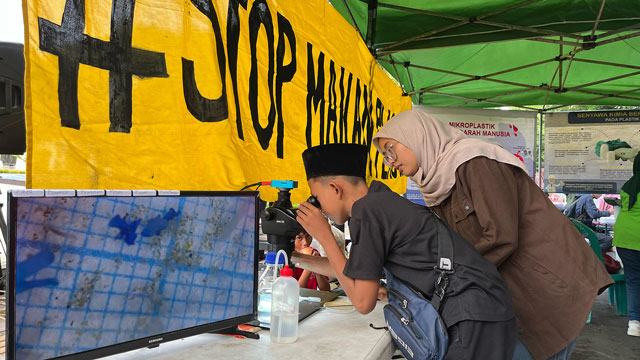 Ecoton mengajak masyarakat untuk melihat wujud mikroplastik lewat mikroskop. Foto: Ecoton