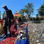 Ecoton pasang alat penjaring sampah di Kali Tebu Surabaya. Foto: Ecoton